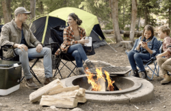 父母和兩個孩子坐在Coleman露營設備營火旁